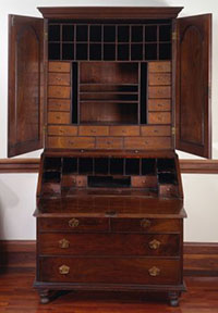 Desk with large drawers and cabinet doors open and showing smaller drawers and cubbies.